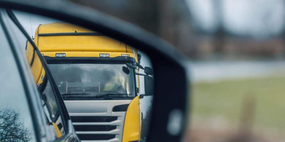 Yellow truck reflection in rear-view mirror
