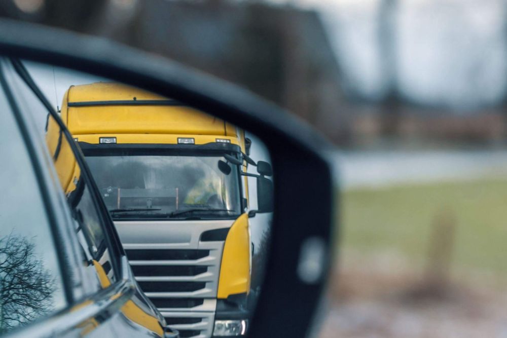 Yellow truck reflection in rear-view mirror