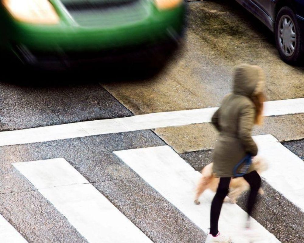 Mujer cruzando la calle delante de