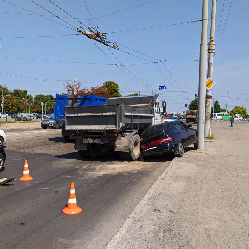Truck and car collision at city intersection with traffic cones marking the scene.