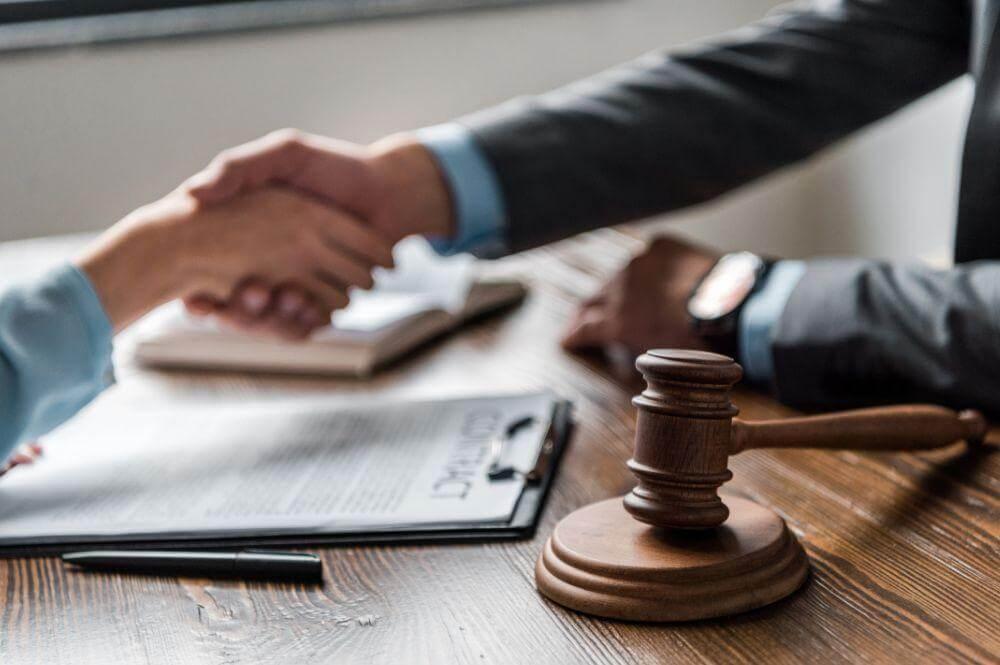 Lawyer and client shaking hands over a table